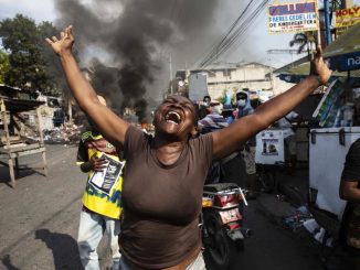 Haitian woman arms outstretched in chaotic protest 2023