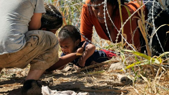 Migrants crossing southern border under concertina wire