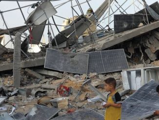 Children stand with bombed solar panels in gaza
