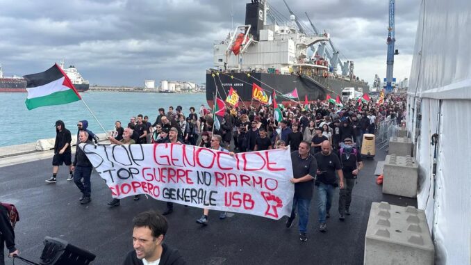 Dockworkers and supporters march at the port of Livorno, Italy, Sept. 22, 2025, carrying Palestinian flags and a USB union banner opposing war and rearmament